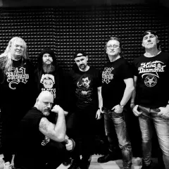 Sześciu mężczyzn w czarnych koszulkach z zespołami, w tym z King Diamond. Widać, że mają w sobie mnóstwo **wena** do tworzenia muzyki.