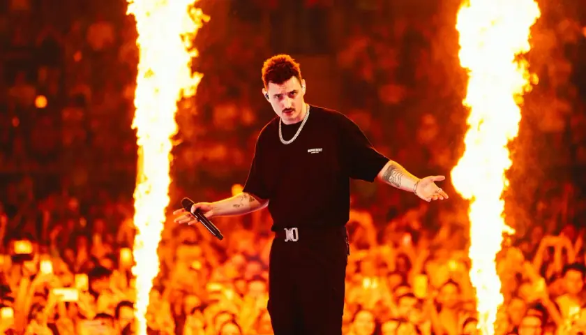 Dawid Podsiadło na scenie, otoczony płomieniami, zapowiada swoje koncerty 2026. Tłum szaleje!