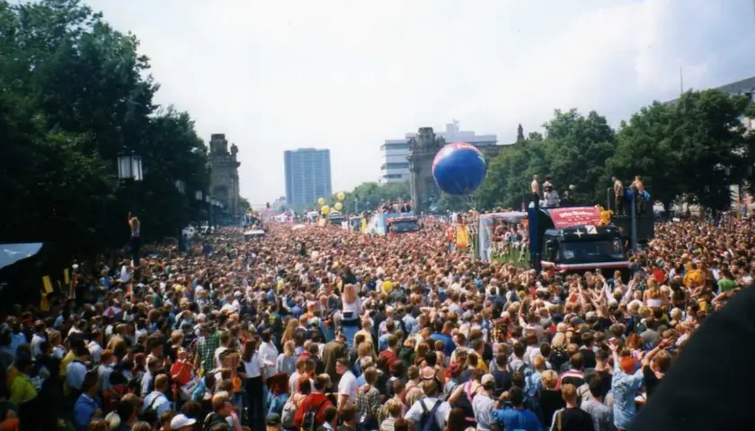 Tłum ludzi na ulicy podczas Love Parade Berlin. Wielki niebieski balon unosi się nad głowami.