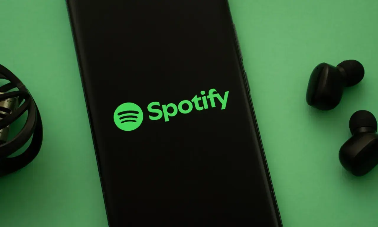 Telefon z logo Spotify i słuchawkami. Słuchaj muzyki na Spotify za darmo!