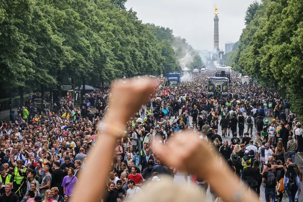 Tłum ludzi na ulicy, ciężarówki z muzyką i Złota Zwycięzca w tle. To jest **love parade** w pełnej krasie!
