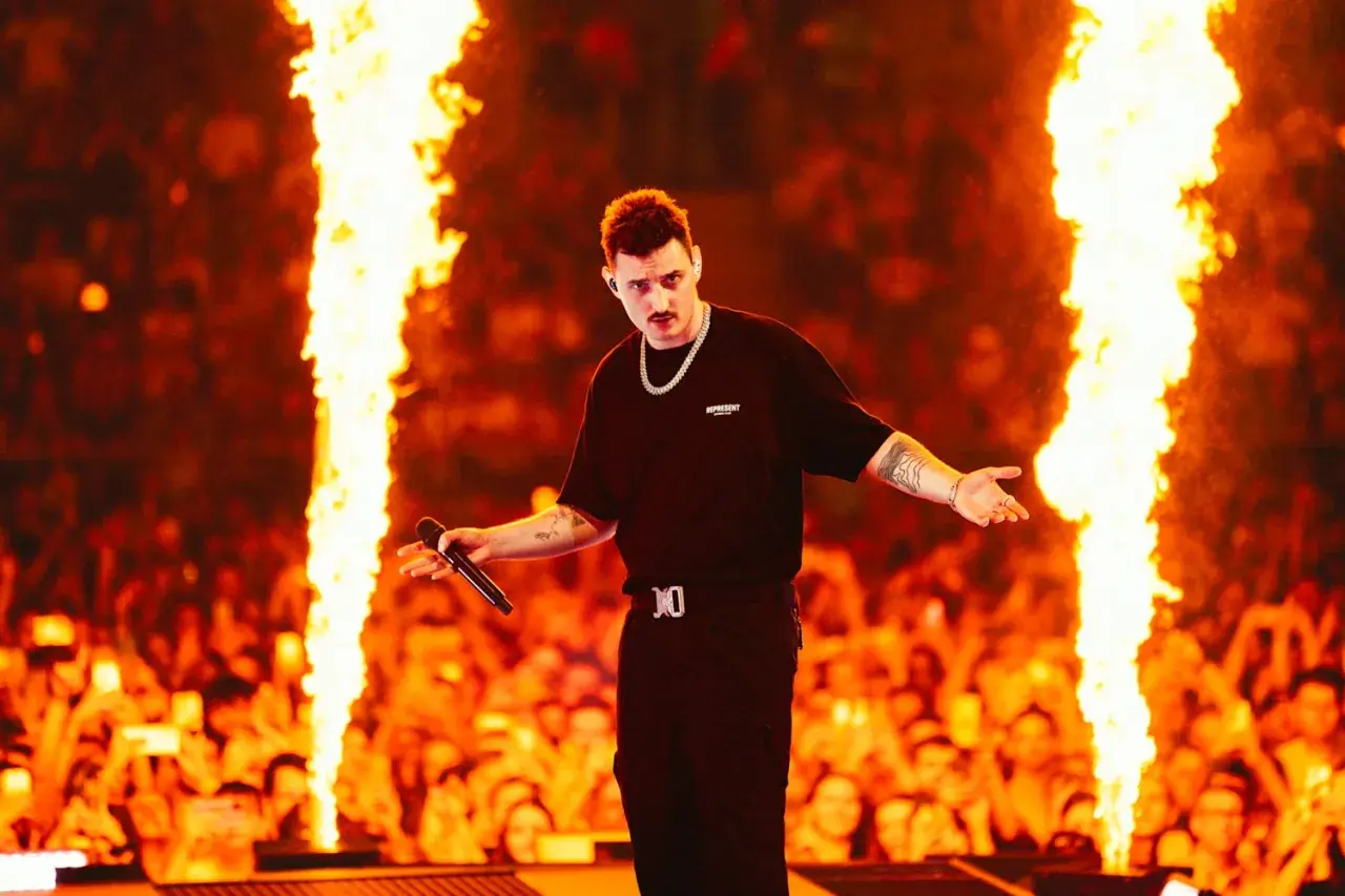 Dawid Podsiadło na scenie, otoczony płomieniami, zapowiada swoje koncerty 2026. Tłum szaleje!