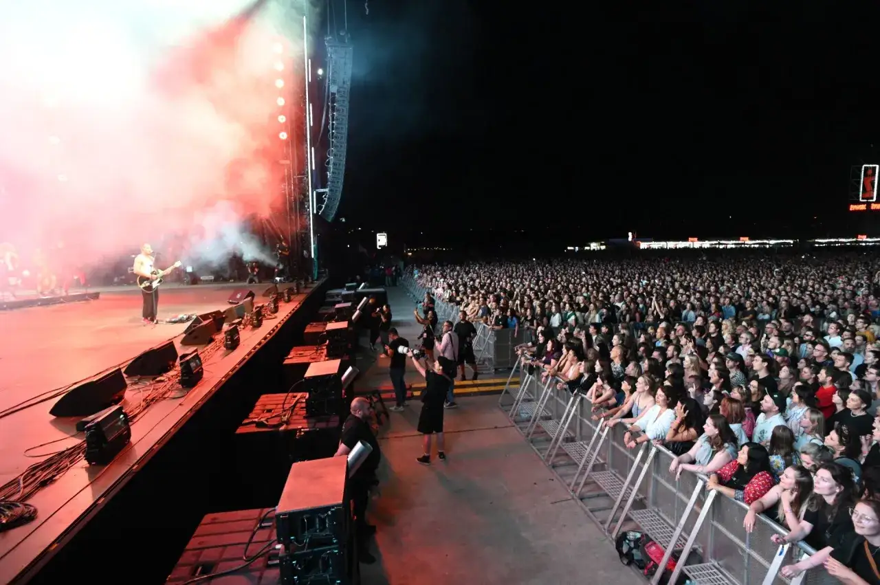 Koncert na żywo w Warszawie, tłum ludzi na Meskie Granie, artysta gra na gitarze.