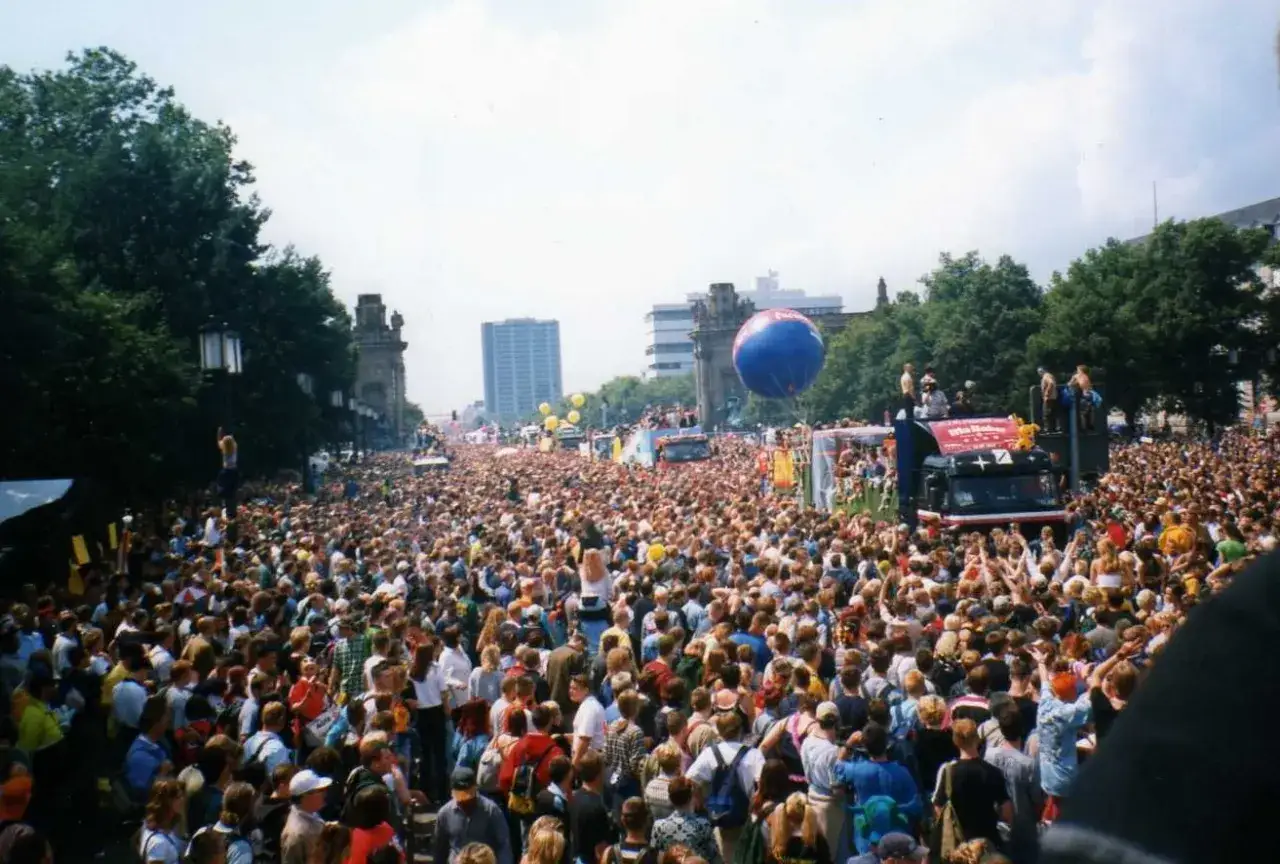 Tłum ludzi na ulicy podczas Love Parade. Wielki niebieski balon unosi się nad głowami.