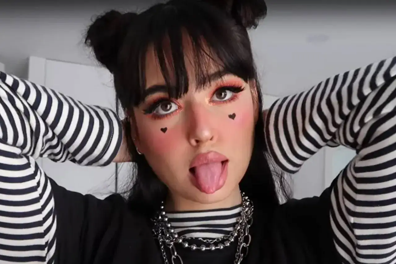 Dziewczyna w stylu alternatywki z czarnymi kucykami, makijażem z serduszkami i w paski.